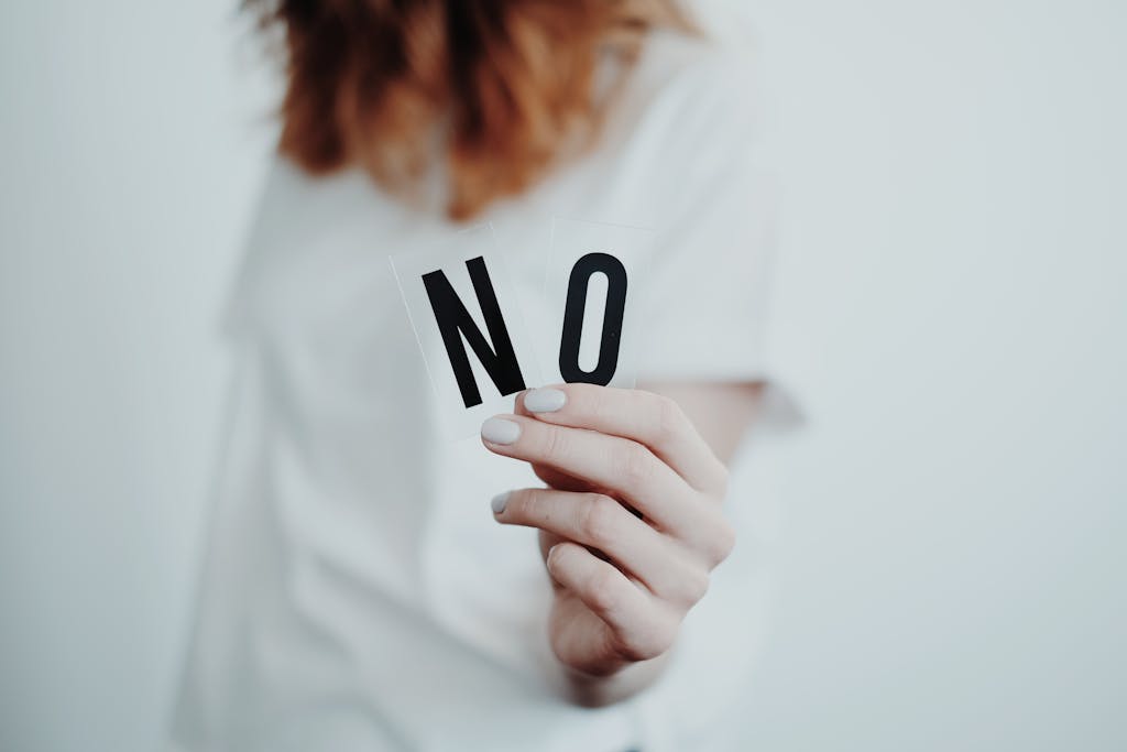 A busy mom setting boundaries. Close-up of a person holding a "No" sign, symbolizing rejection or disagreement. 